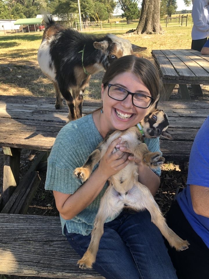 Girl At Goat Farm Holding Baby Goat